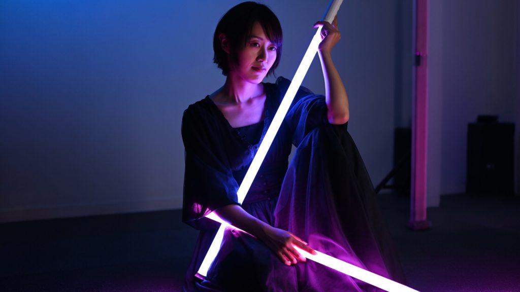 女性写真家Rinaty先生が棒のライトを持ってモデルになっている。