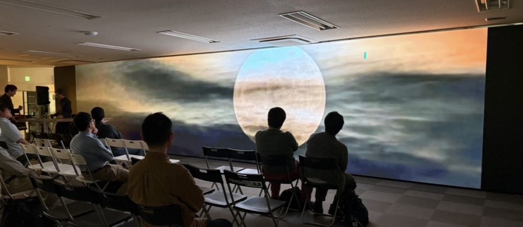 幻想的な月の映像を見ている参加者たち。