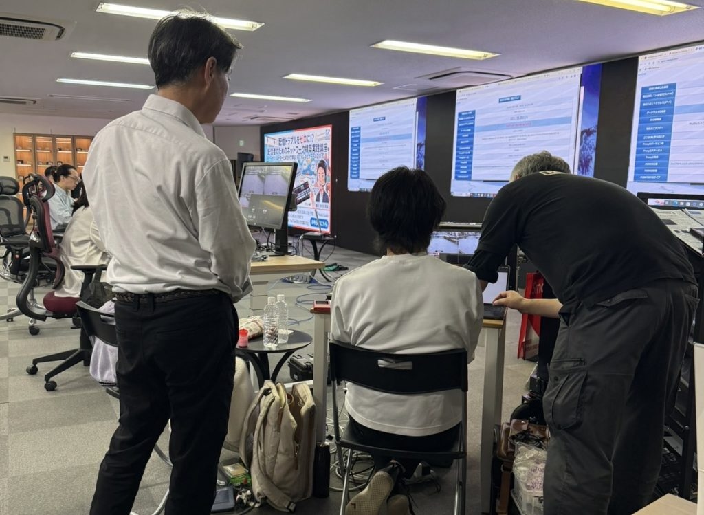 講師がPCの前でレクチャーする。参加者がそれを見て学んでいる。