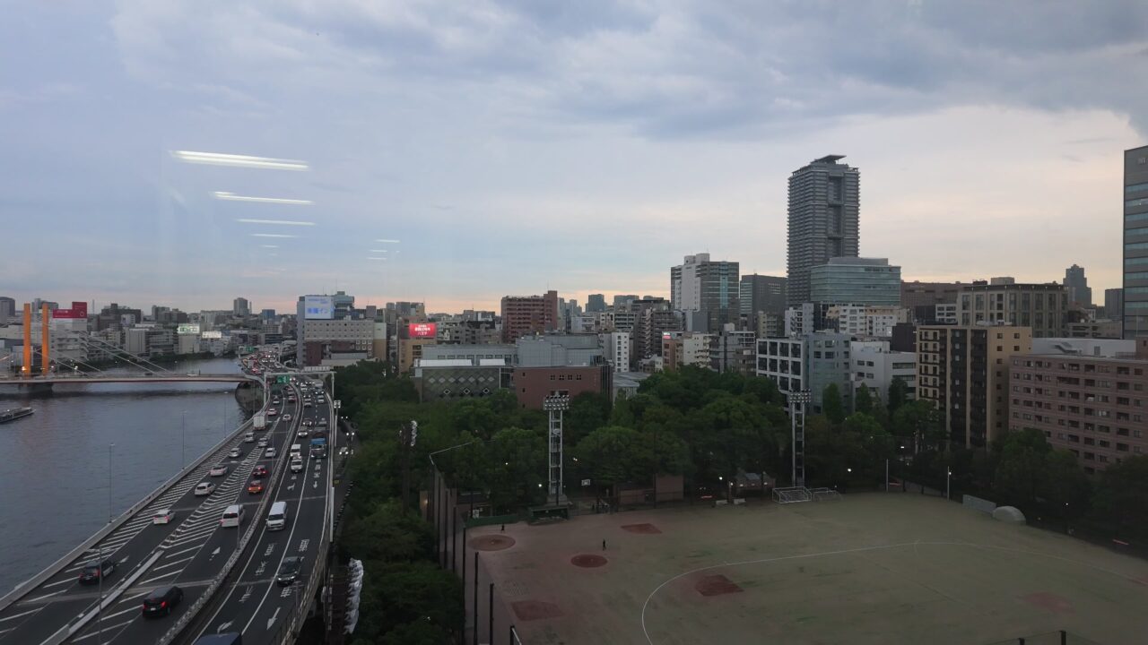 夕方の隅田川方面。パンの終盤で野球場と高層ビルが画面に収まっている